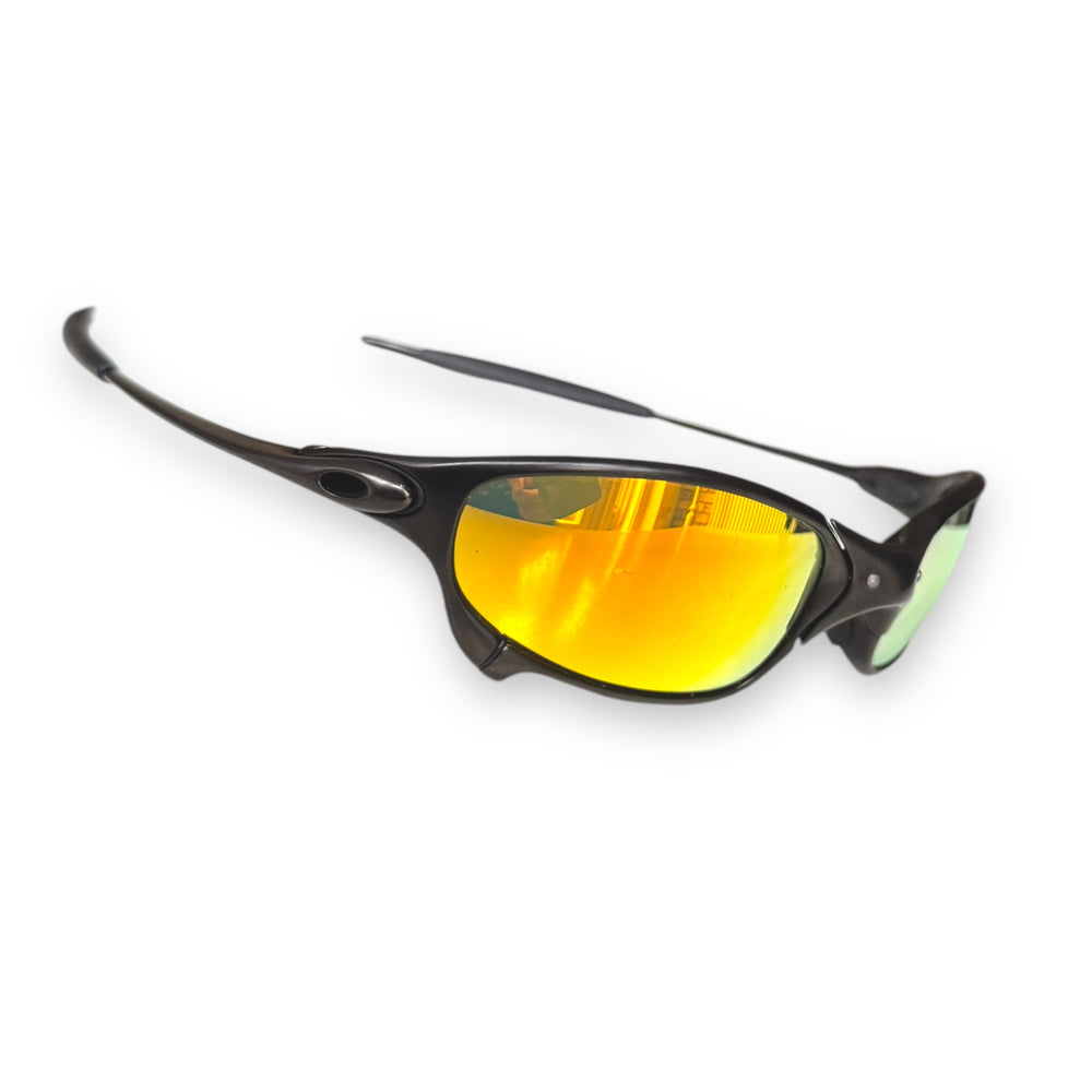 Reference Oakley Juliet with a dark metal frame and gold mirrored lenses.